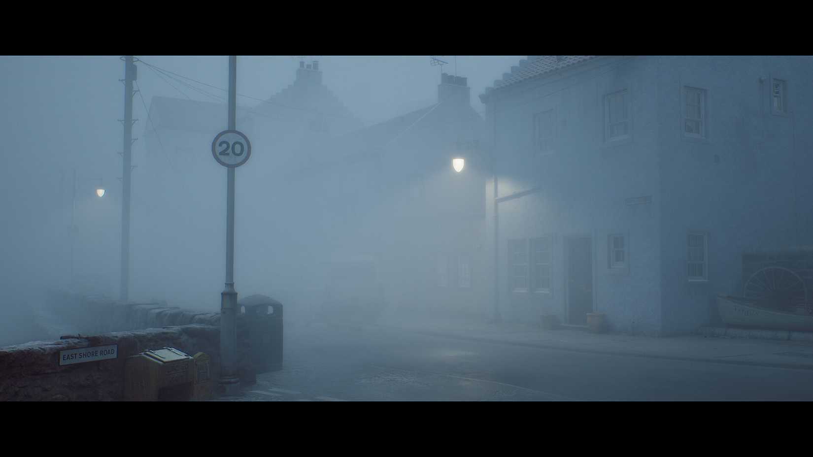 a foggy road lit by a streetlight